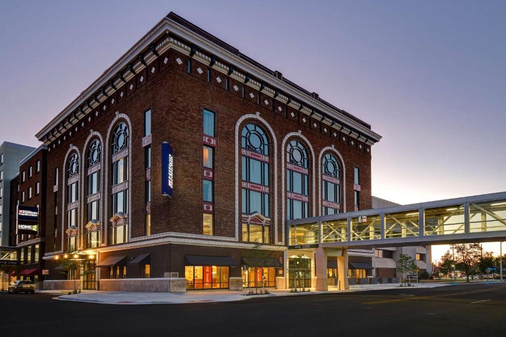 卡拉马祖Hilton Garden Inn Kalamazoo Downtown的前面有一座桥的大砖砌建筑