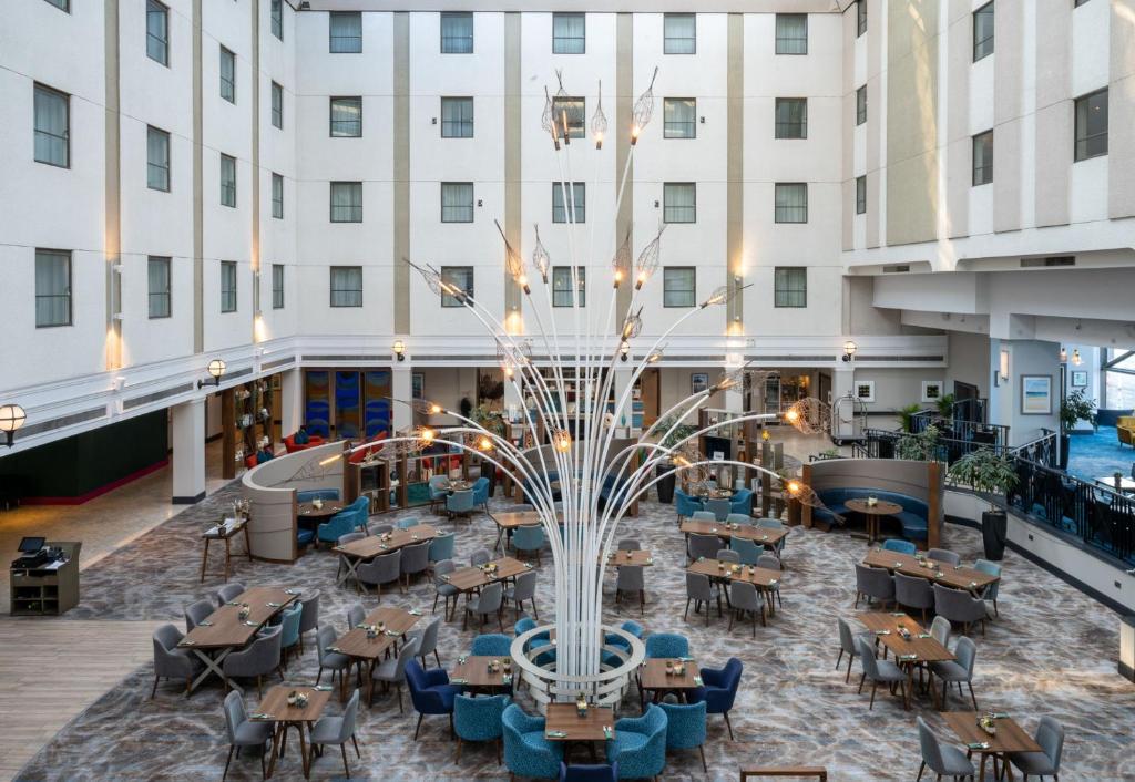 布莱顿霍夫Leonardo Royal Hotel Brighton Waterfront的享有酒店中庭的景色,配有桌椅