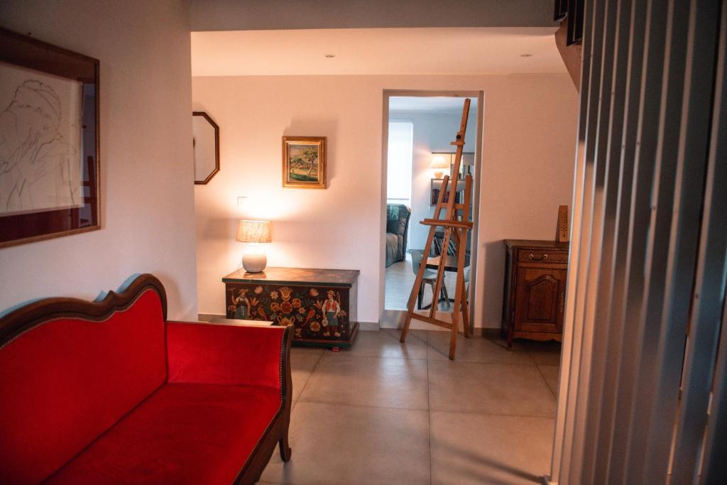 泽斯河畔多森赫恩La Maison du cèdre的客厅配有红色的沙发和桌子