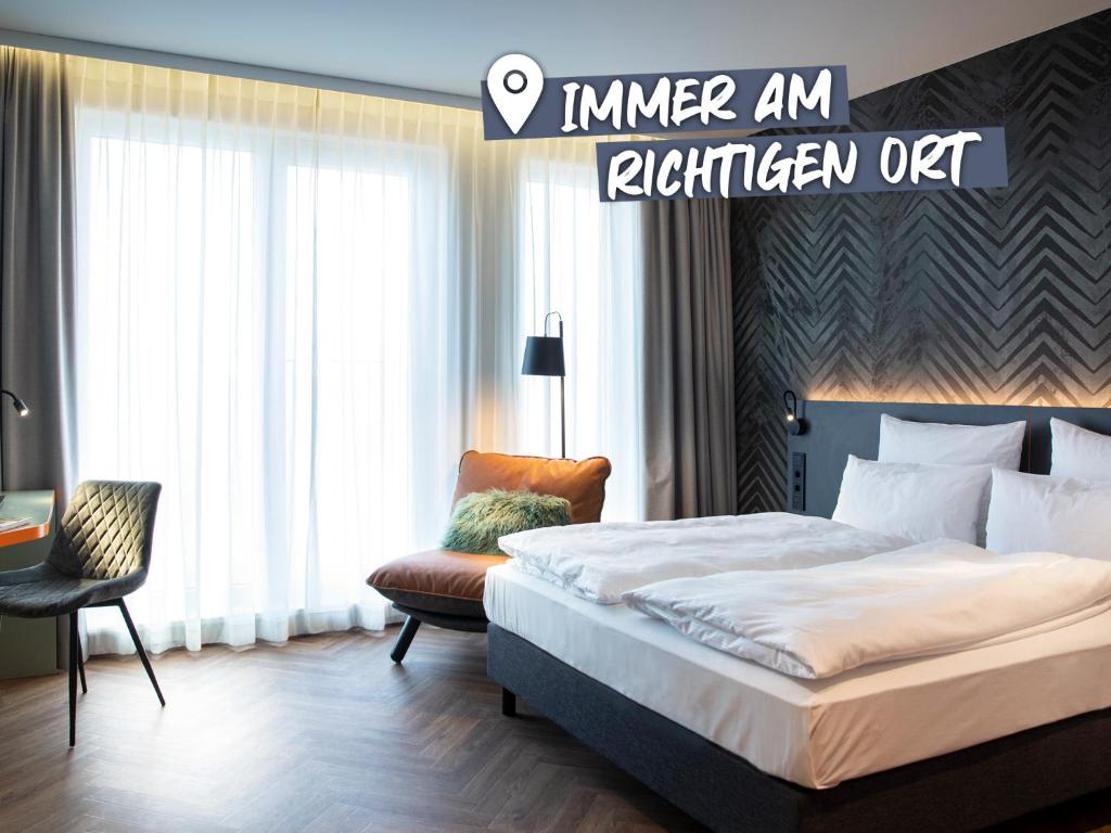 柏林LOGINN Hotel Berlin Airport的配有一张床和一把椅子的酒店客房