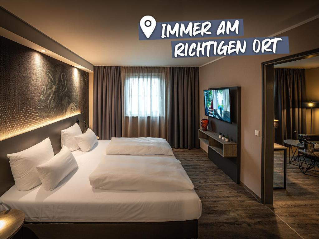 斯图加特LOGINN Hotel Stuttgart Zuffenhausen的酒店客房设有两张床和电视。