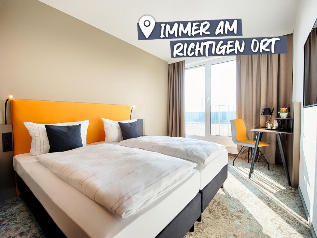 莱比锡LOGINN Hotel Leipzig的一间卧室配有一张带橙色床头板的大床
