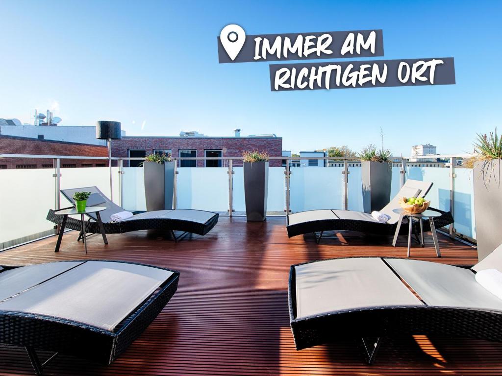 不莱梅ACHAT Hotel Bremen City的屋顶上带桌椅的阳台
