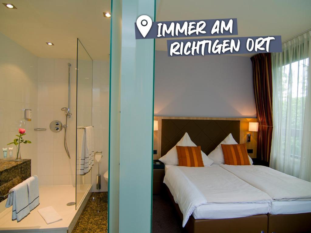 慕尼黑ACHAT Hotel München Süd的酒店客房配有一张床和淋浴