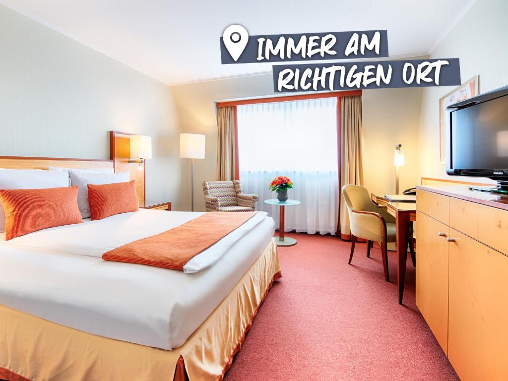 卡尔斯鲁厄ACHAT Hotel Karlsruhe City的配有一张床和一台平面电视的酒店客房