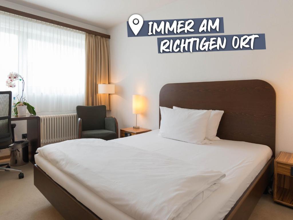 弗赖辛ACHAT Hotel Corbin München Airport的配有一张床和一把椅子的酒店客房