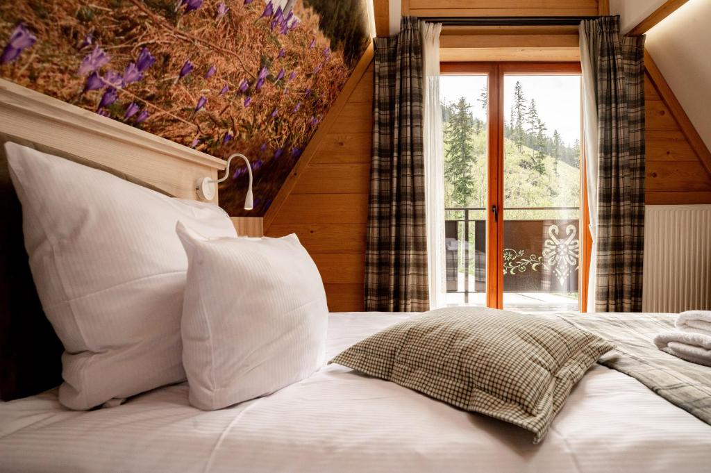 考斯赛力克Ku Dolinie的卧室配有带白色枕头的床和窗户。