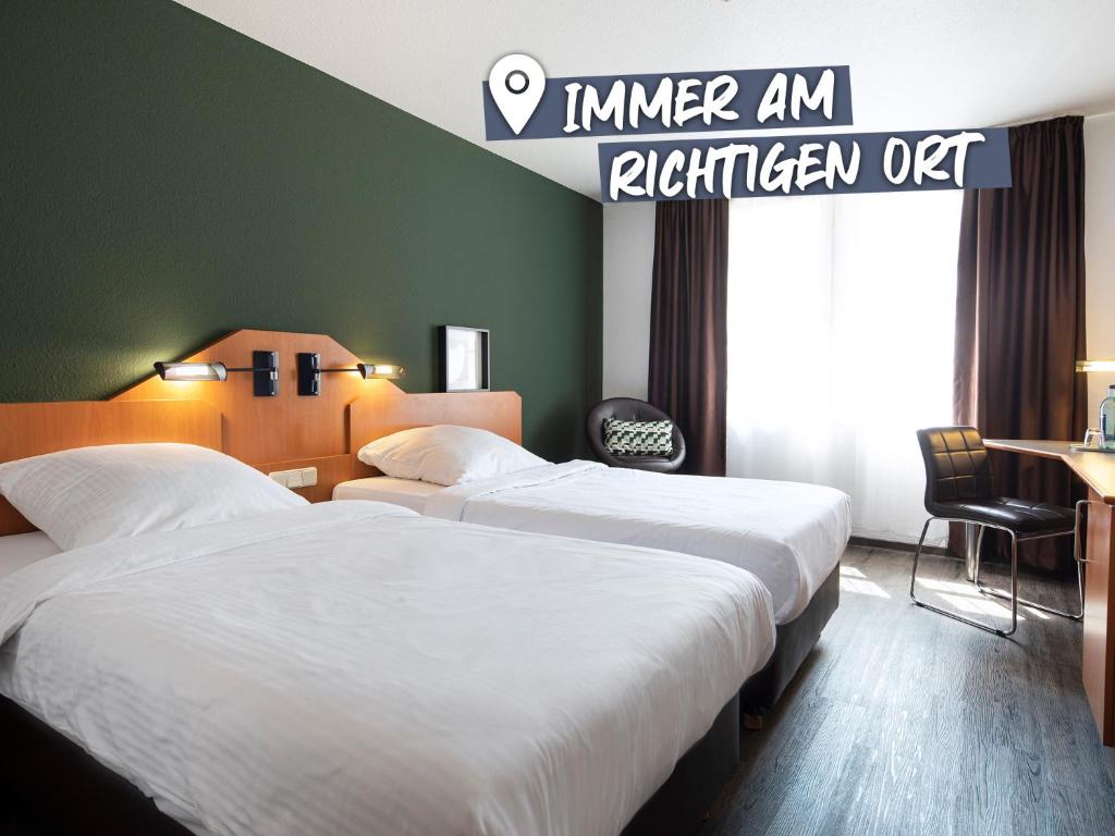 贝格施特拉瑟黑彭海姆ACHAT Hotel Heppenheim的标牌的酒店客房内的两张床