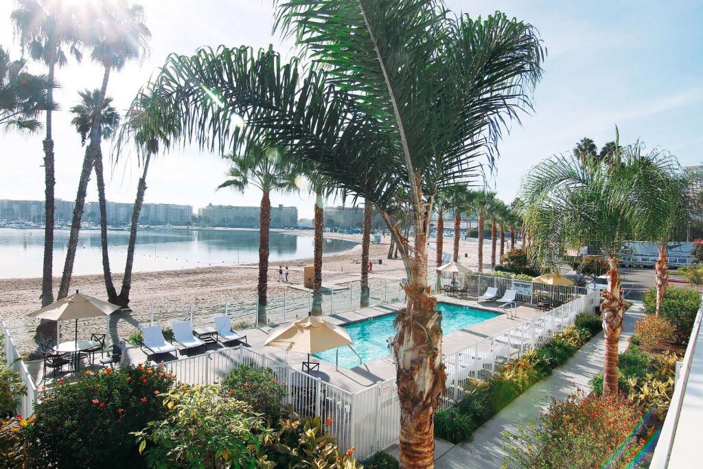 洛杉矶Jamaica Bay Inn Marina Del Rey Tapestry Collection by Hilton的拥有游泳池、棕榈树和海滩的度假胜地