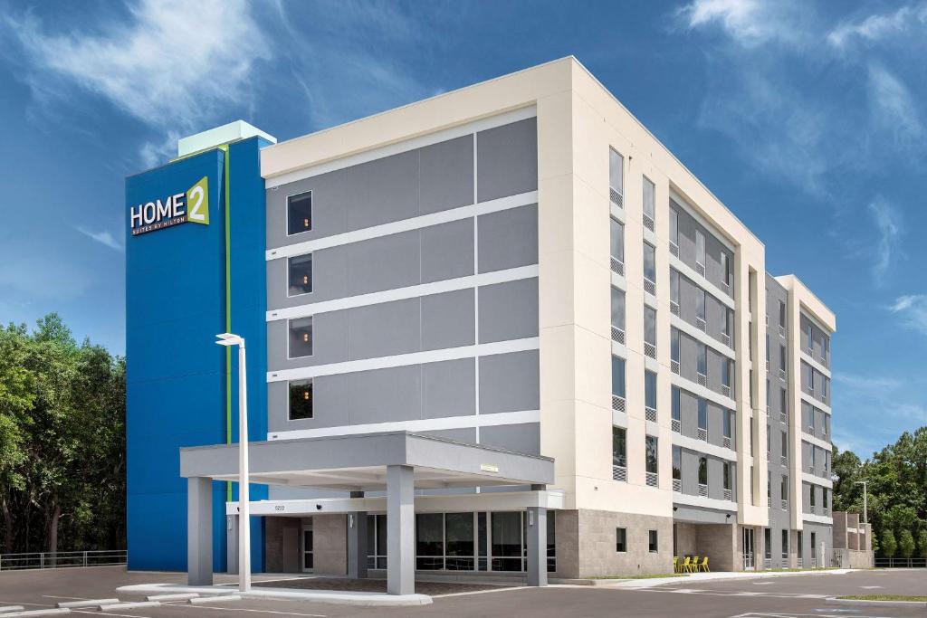 坦帕Home2 Suites By Hilton Tampa Westshore Airport, Fl的前面有蓝色标志的大型白色建筑
