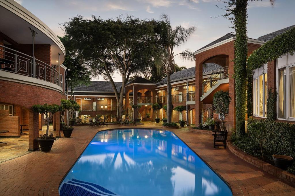 约翰内斯堡Premier Hotel Falstaff的一座房子庭院中的游泳池