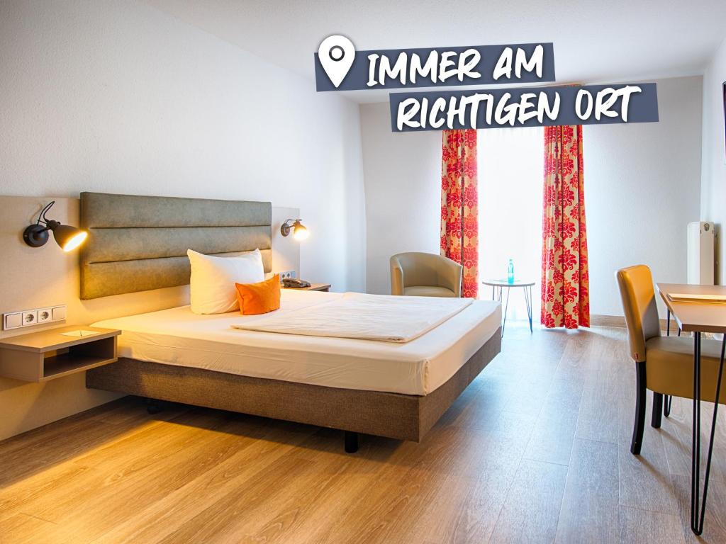 茨维考ACHAT Hotel Zwickau的一间卧室配有一张床和一张桌子