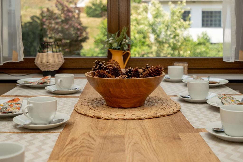 苏尔Ferienwohnung Suhl/ Wichtshausen的一张木桌,上面有一碗松锥