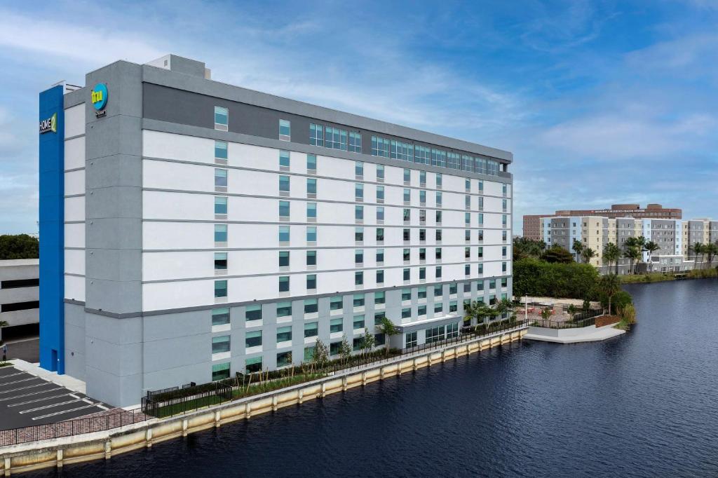 迈阿密Home2 Suites By Hilton Miami Airport South Blue Lagoon的水体旁的白色大建筑