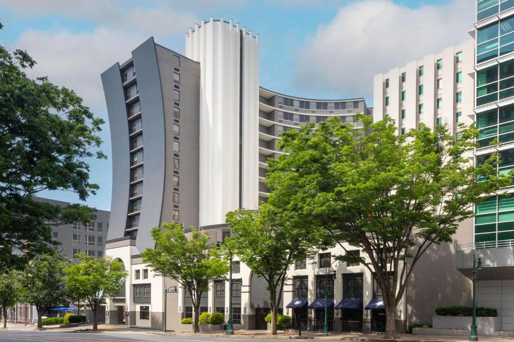 银泉DoubleTree by Hilton Silver Spring Washington DC North的一座高大的白色建筑,前面有树木