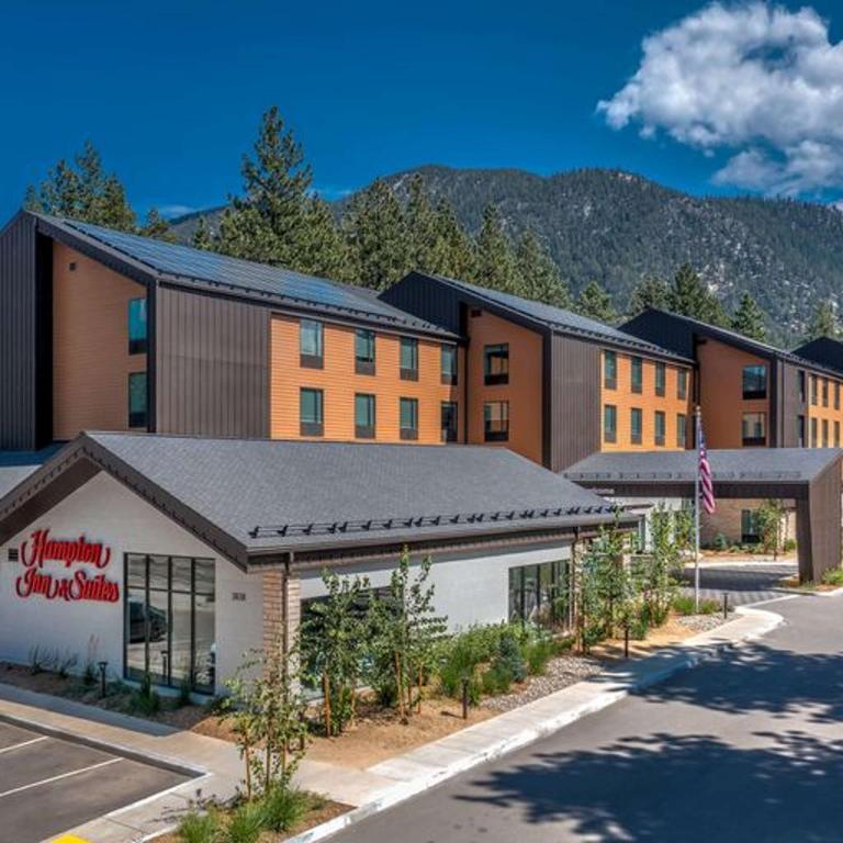 南太浩湖Hampton Inn & Suites South Lake Tahoe的前面有一座树木的建筑