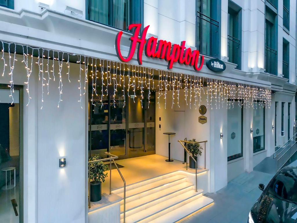 伊斯坦布尔Hampton By Hilton Istanbul Old City的 ⁇ 虹灯标志的建筑物前方的商店