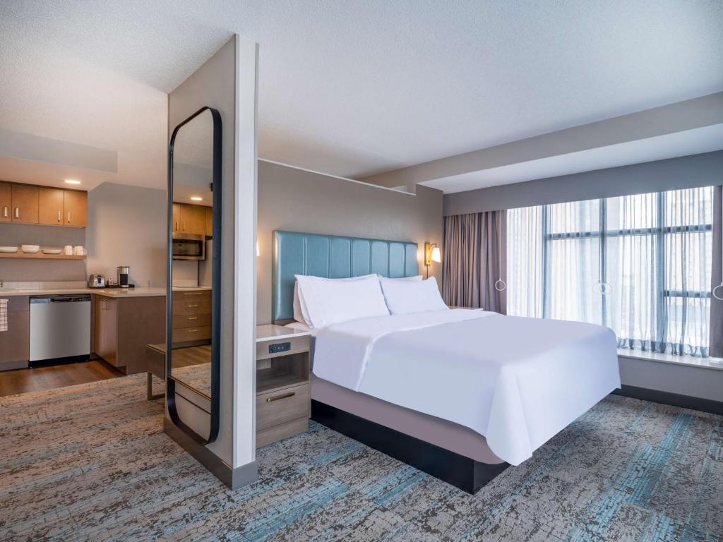 托莱多Homewood Suites By Hilton Toledo Downtown的卧室设有白色的床和大窗户