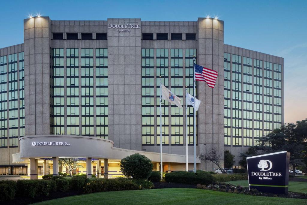 樱桃山DoubleTree by Hilton Cherry Hill Philadelphia的前面有两面旗帜的建筑