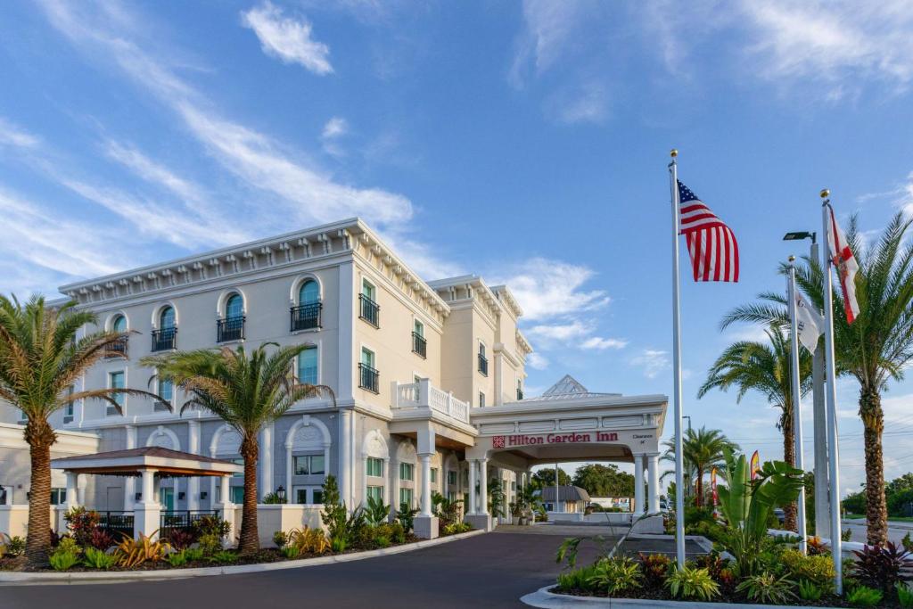 圣奥古斯丁Hilton Garden Inn St Augustine-Historic District的拥有美国国旗和棕榈树的酒店