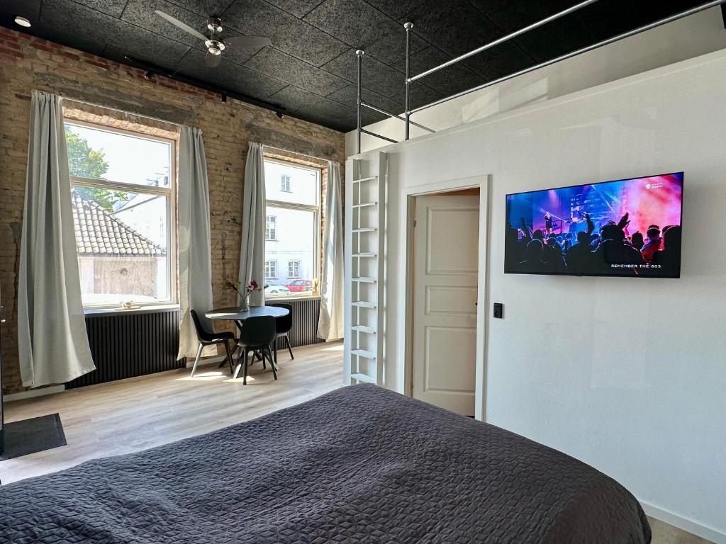 马里博Torvet17 Nr2 - 25m2的卧室配有一张床和壁挂式平面电视。