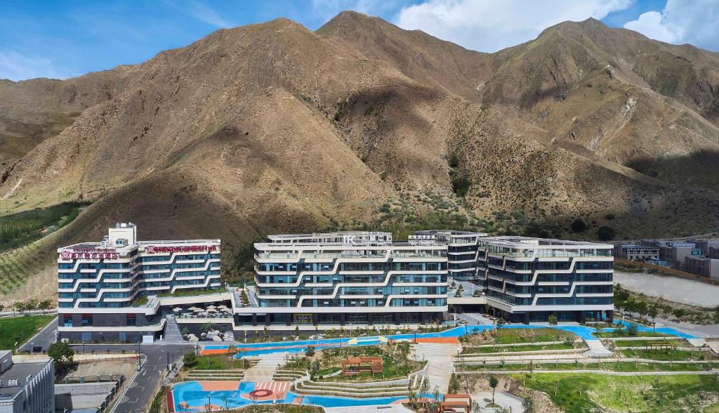 拉萨拉萨天峰希尔顿花园酒店的享有度假胜地的空中景致,以山脉为背景