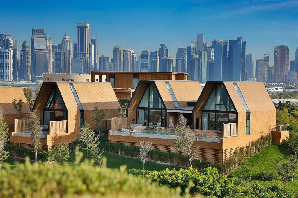多哈Katara Hills Doha, Lxr Hotels & Resorts的两座以城市为背景的单元房屋
