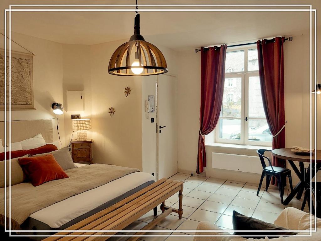里翁山区APPART HOTEL Place des Jolis Rêves的一间卧室配有一张床、一张桌子和一个窗户。