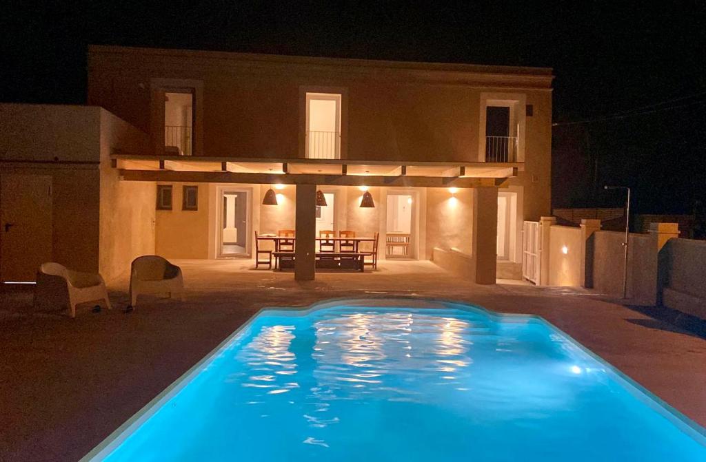 代尔特布雷Villa Barracot的夜间在房子前面的游泳池