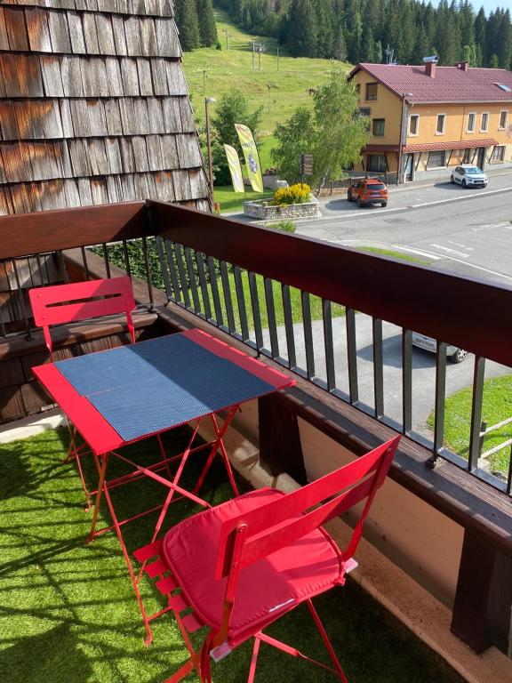 米茹APPARTEMENT DE MONTAGNE的阳台配有3把椅子和1张桌子