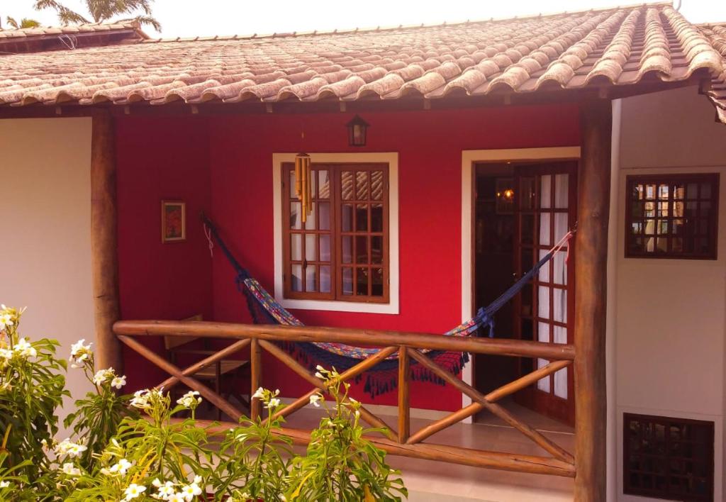 伦索伊斯Apartamento Vivendas do Serrano的一座红色的小房子,设有木甲板
