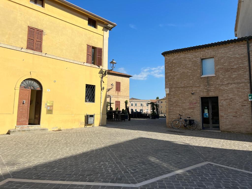 西尼加利亚Residenza del Duca的两栋建筑之间的小巷里一条鹅卵石街道