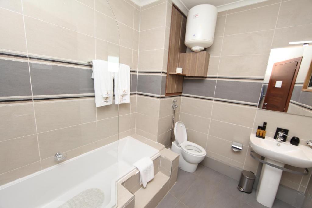 杜阿拉Hotel La Falaise Bonapriso的浴室配有卫生间、盥洗盆和浴缸。