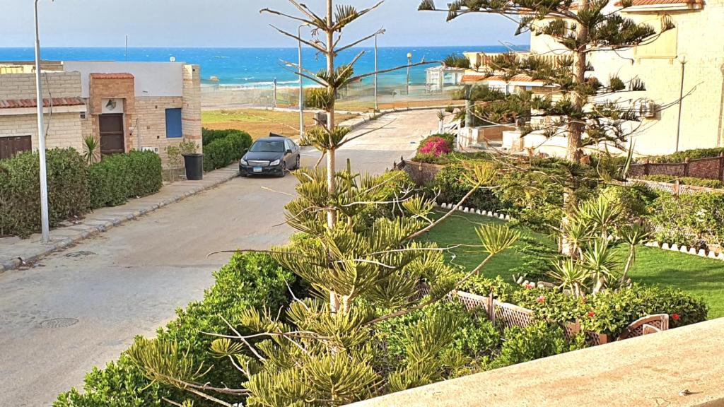 阿莱曼Stunning 5-Bedroom Villa with Breathtaking Sea Views & Roof Penthouse at Badr resort North Coast El Alamein !! الساحل الشمالي的停在海边的街道上的汽车