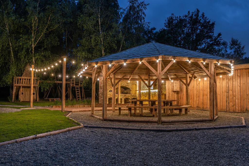 Moon Glamping Resort的木制凉亭配有野餐桌和灯