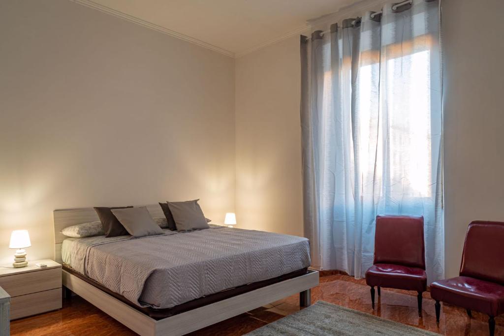 罗马La Maison D'Amelia的一间卧室配有一张带两把椅子的床和一扇窗户