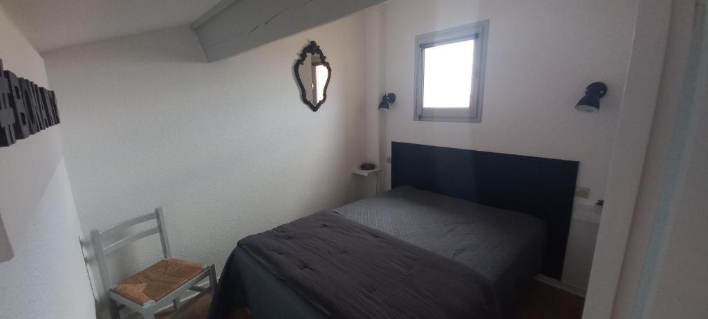 乐巴凯尔斯location maison de vacances jusqu&#39;à 6 personnes près du port et de la plage的一间有床和窗户的小卧室