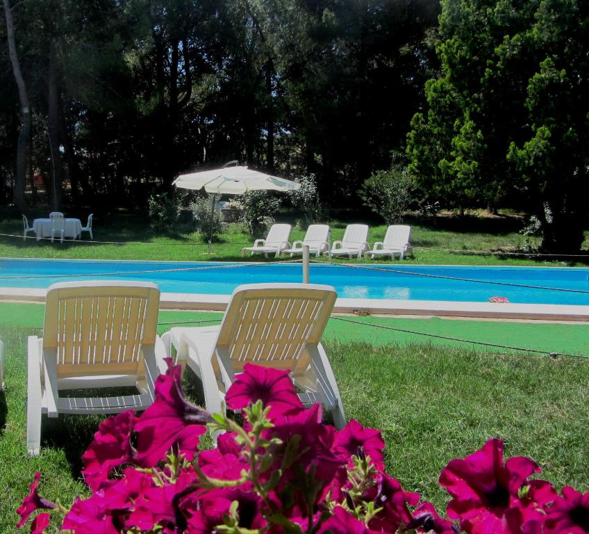 LandroFeudo Tudia的游泳池旁的两把椅子和一把遮阳伞