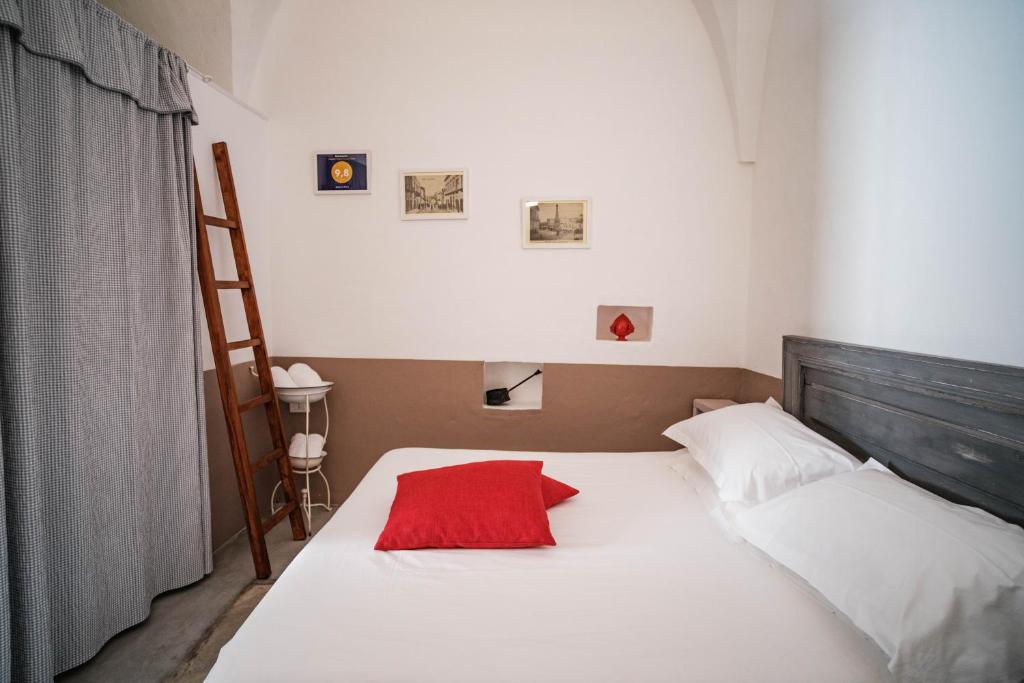 奥斯图尼Casa Le Mura的一间卧室配有一张红色枕头的床