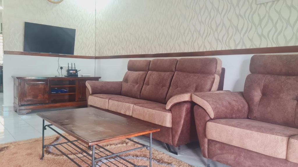 万津Anjung KLIA House 31 With Neflix & Airport Shuttle的客厅配有沙发和桌子