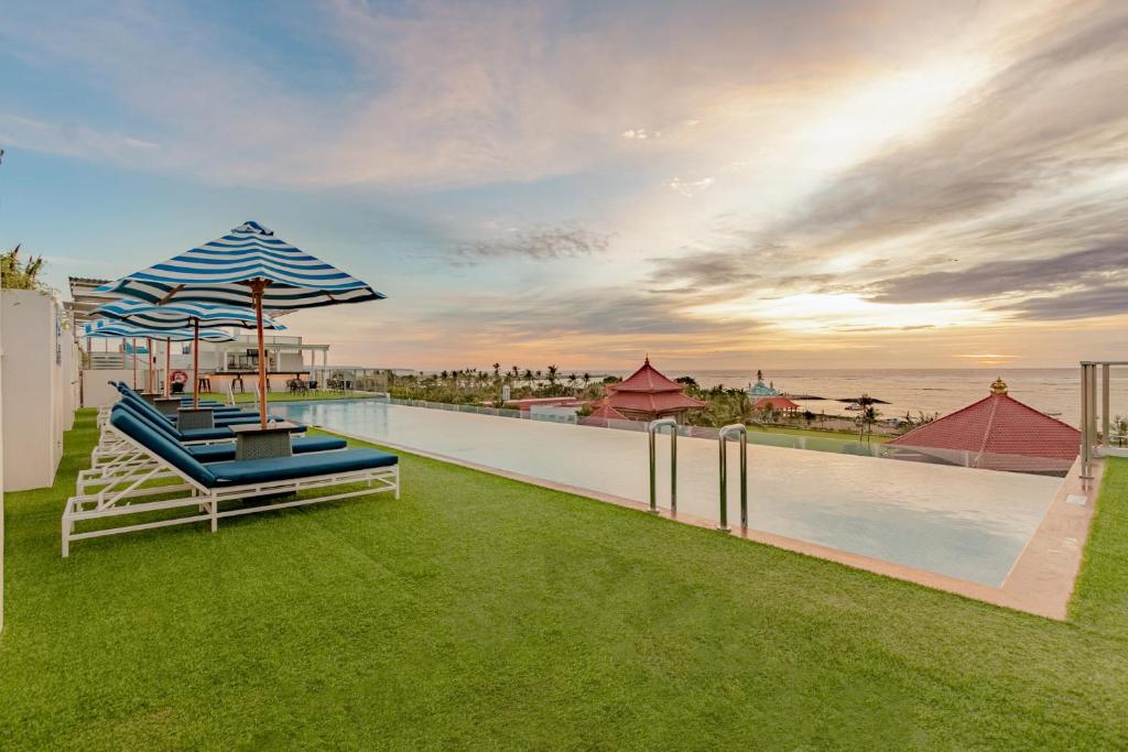 库塔巴鲁纳智选假日酒店的一个带椅子和遮阳伞的草地游泳池