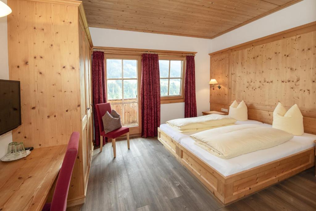 阿尔卑巴赫落叶松旅馆的一间卧室设有一张大床和一个窗户。