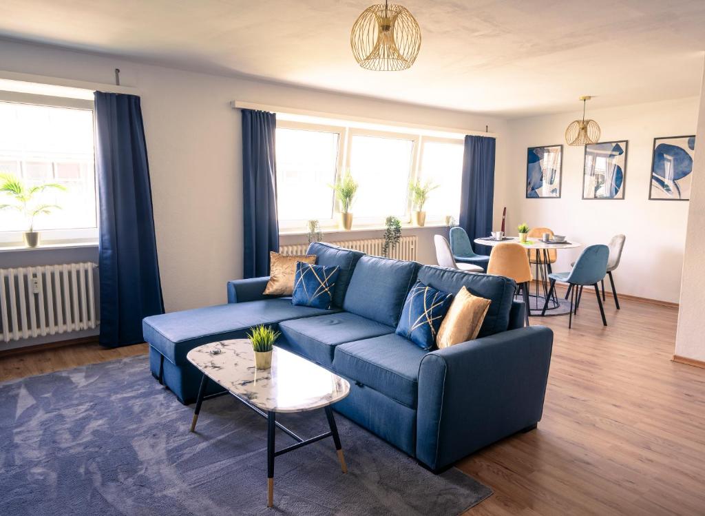 莱茵河畔路德维希港City Loft - 5 Min Rhein-Galerie的客厅配有蓝色的沙发和桌子