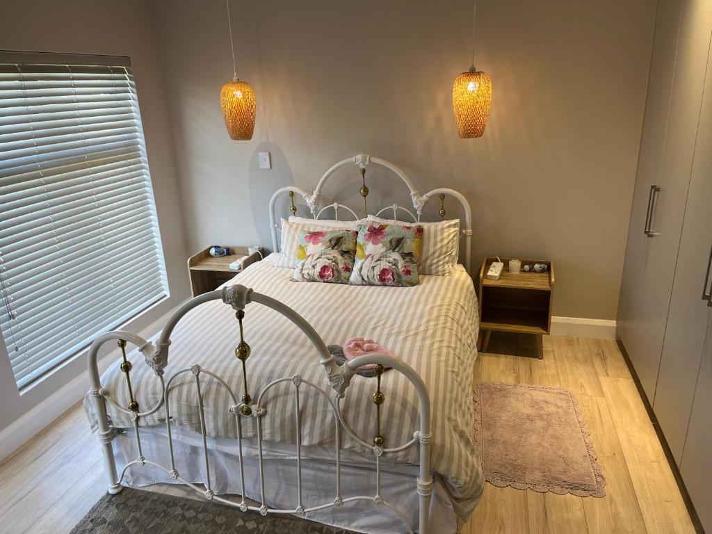 乔治Metanoia Kingswood Golf Estate的一间卧室配有一张带白色床罩和枕头的床。