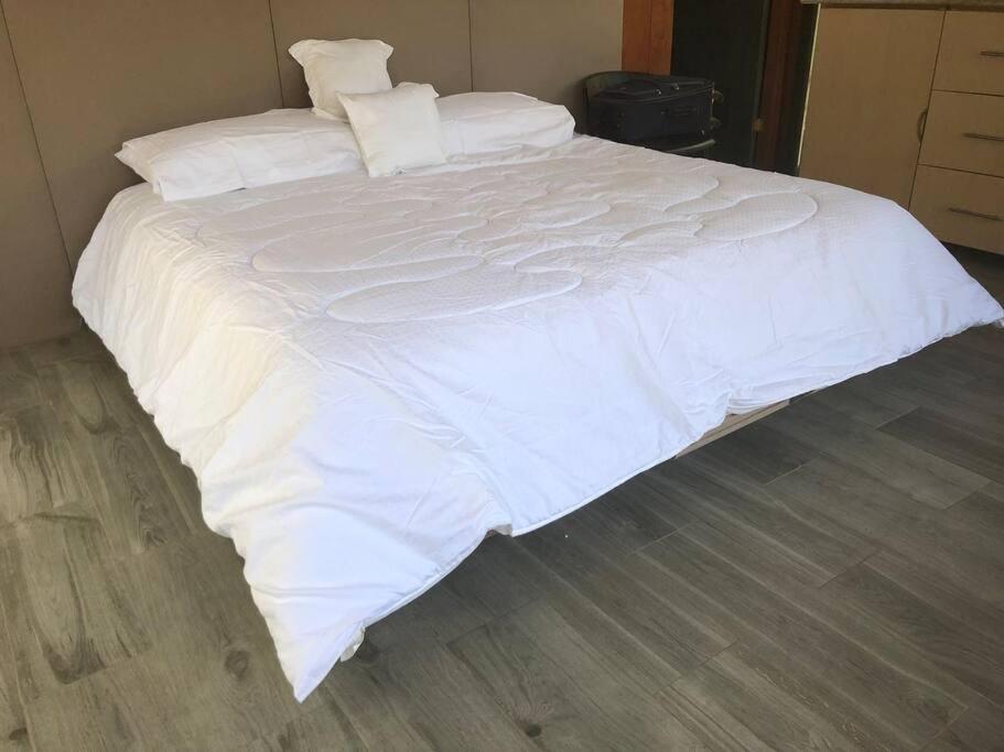 利比里亚Cabaña de montaña espectacular的一张白色大床,配有白色床单和枕头