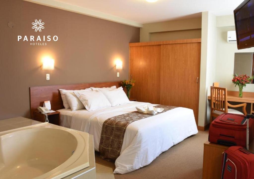 特鲁希略Hoteles Paraiso TRUJILLO的酒店客房配有一张床和浴缸。