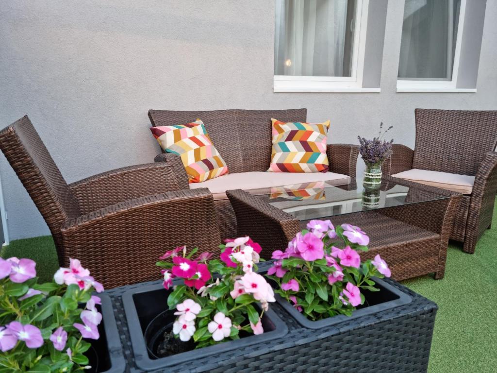 艾斯特根Center home Belvárosi kis lakás, csendes udvarral的庭院设有藤椅和鲜花桌。