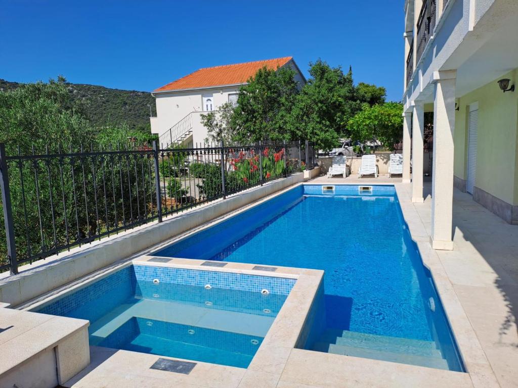 维尼斯切Apartments Neli的一座游泳池,位于一座建筑旁的院子内