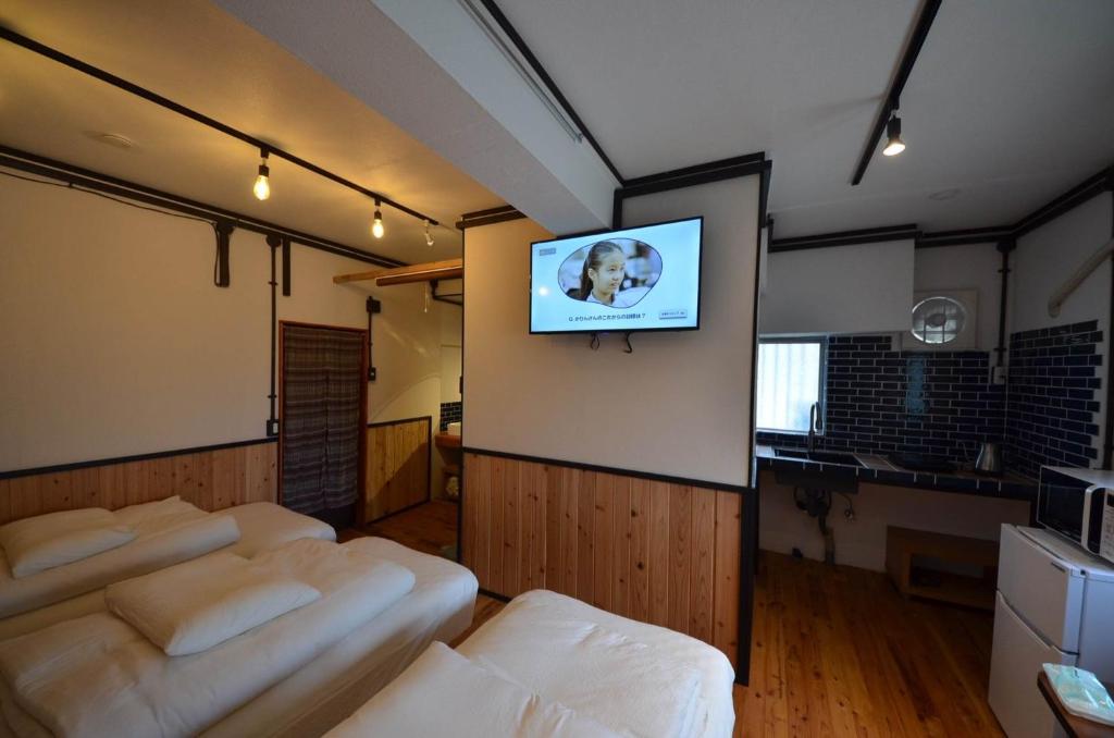 那霸GRANDPA'S HOUSE Barchanchi - Vacation STAY 53569v的一间房间,墙上有一堆椅子和一台电视