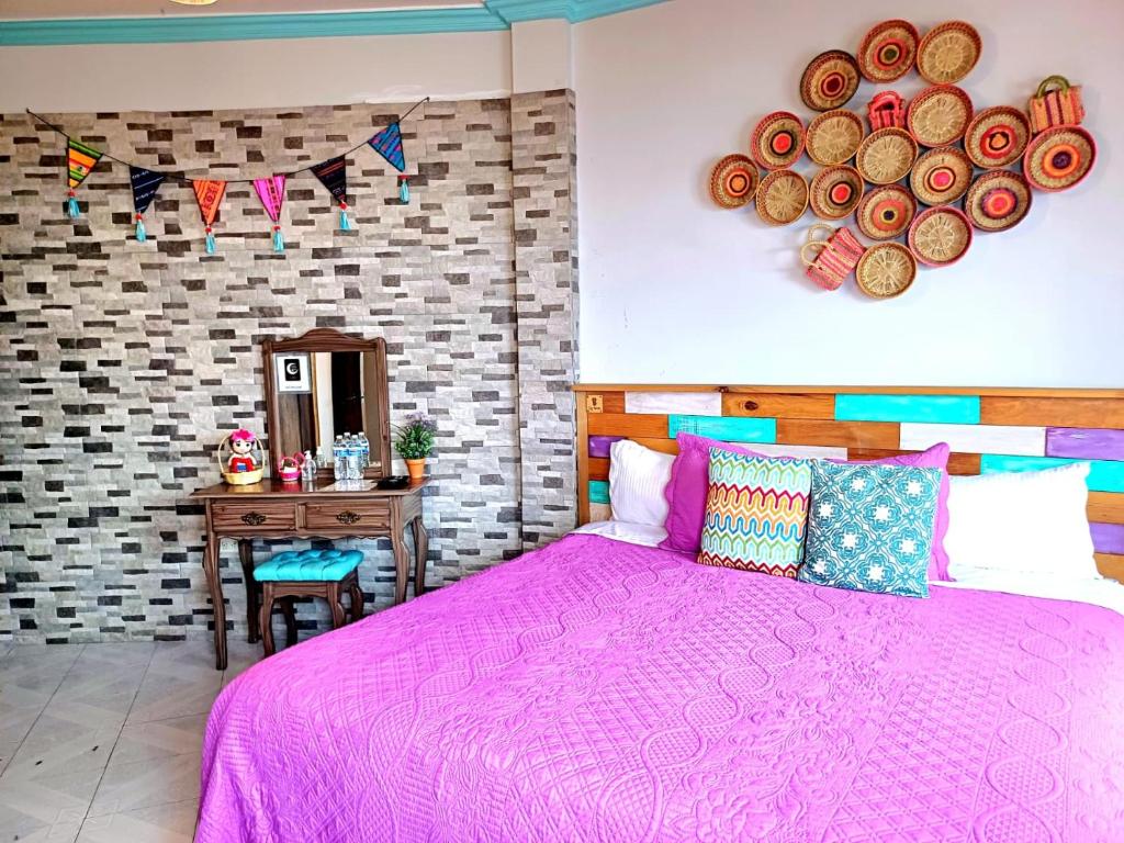 瓜纳华托卡萨奥姆布里格鲁纳民宿的卧室配有粉红色的床和桌子